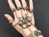 une image représentant la main d'une femme portant un bracelet à maillons et d'autres bracelets