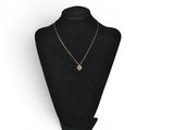a black mannequin with a gold necklace on it