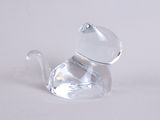 a clear glass cat figurine sitting on a white surface