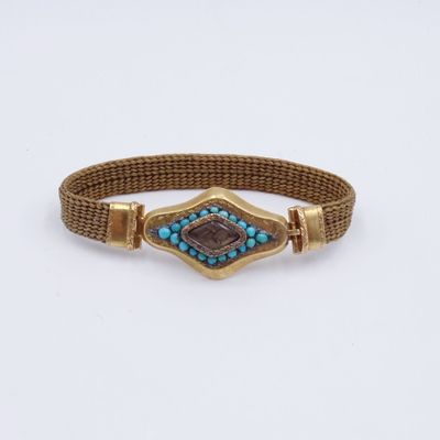 un gros plan d'un bracelet orné d'une pierre bleue