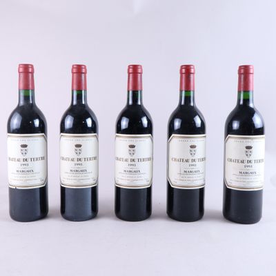 quatre bouteilles de vin rouge sont alignées sur une surface blanche