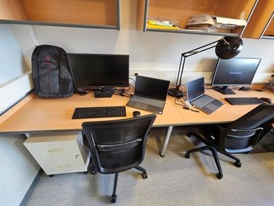 a desk with two computers and a laptop on it