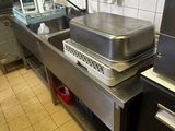 stainless steel counter top in a commercial kitchen with a sink and dishwasher