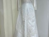 une robe de mariée blanche posée sur un mannequin devant une vitrine