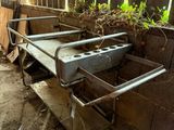 a metal bed in the middle of a dirty room