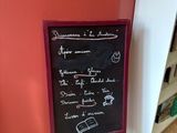 un tableau noir sur lequel sont écrites des notes, dans un coin de la pièce