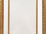 un miroir encadré d'or sur un mur blanc avec un fond blanc