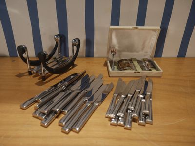 a box of knives and a pair of scissors on a table