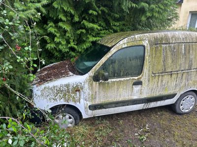 une camionnette garée dans l'herbe à côté d'un arbre