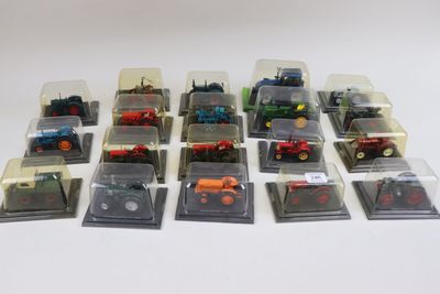 de nombreux tracteurs miniatures dans des boîtes en plastique, posés sur une surface blanche
