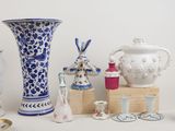 many different vases on a table with a white wall in the background