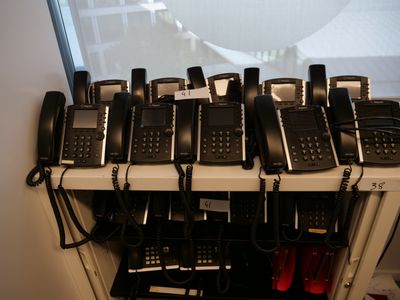 beaucoup de téléphones qui prennent la poussière sur une étagère