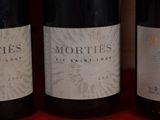 three bottles of wine are lined up on a red table
