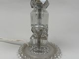 silver plated table lamp with a glass shade on top of it