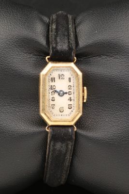 une photo d'une montre-bracelet plaquée or avec un bracelet en cuir noir