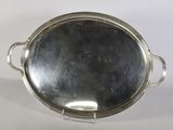 une assiette en argent ancienne avec des poignées et des poignées sur un support