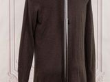 brown sweater on a mannequin stand in front of a white wall