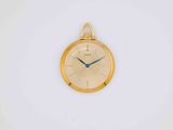 a gold clock on a white wall with a blue second hand