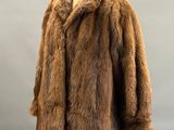 a brown fur coat sitting on top of a wooden mannequin