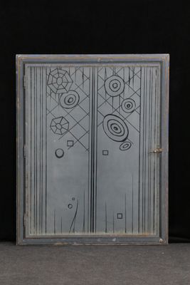 a glass door with a drawing on it in front of a black wall