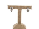 a close up of a pair of skull earrings on a stand