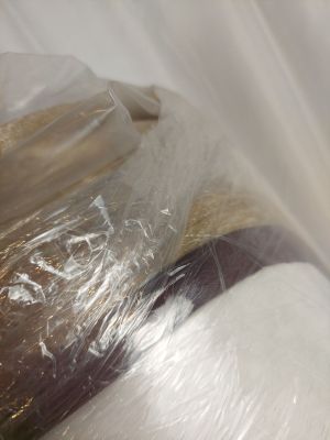 un rouleau de papier toilette emballé dans du plastique posé sur une table