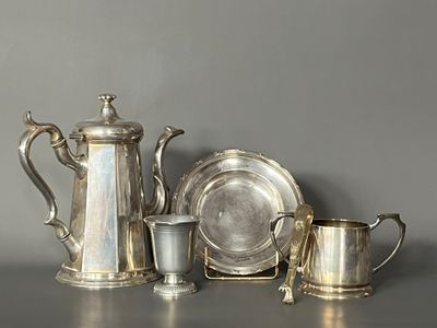 a silver tea pot, a silver plate, a silver cup, and a silver plate