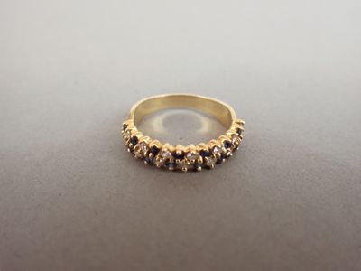 gros plan d'une bague en or avec des pierres noires et blanches