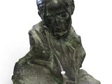 an image of a bronze bust of a man sitting on a rock
