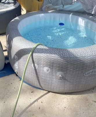 a hot tub that has a hose attached to it