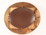 a round mirror with a wooden frame on a white wall