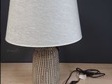 une lampe posée sur une table, dont le cordon est branché