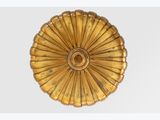 an image of a gold plate with a flower decoration on it