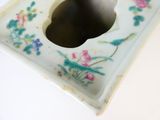 une assiette blanche percée d'un trou et décorée de fleurs peintes