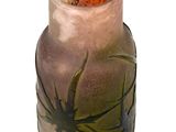 a glass vase with a spider on it on a white surface