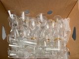 a lot of empty wine glasses in a cardboard box