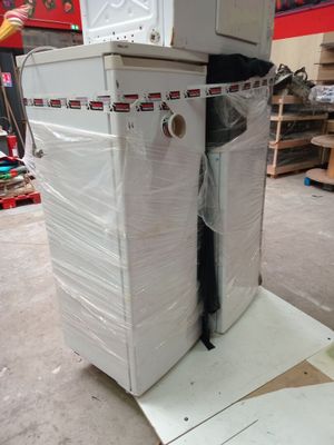 a stack of appliances sitting on top of a cart in a warehouse