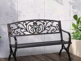 a black bench sitting on a wooden deck next to a potted plant