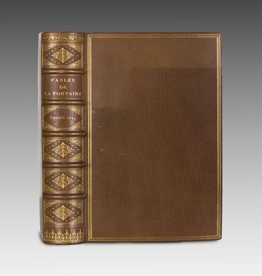 un livre en cuir marron avec des bordures dorées et des bordures dorées