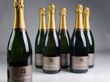 four bottles of champagne are lined up on a table