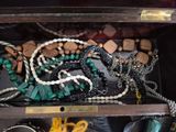 a wooden box filled with lots of jewelry on a table