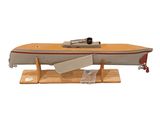 un petit bateau en bois avec une pagaie posée sur un support