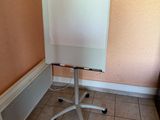un tableau blanc posé sur un support dans un coin de la pièce
