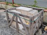 a wooden crate sitting on the ground next to a pile of wood