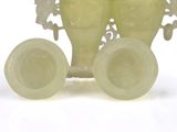 two vases sitting on top of each other on a white surface