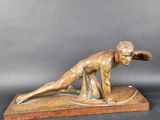 statue en bronze représentant un homme sur une planche de surf, posée sur un socle en marbre
