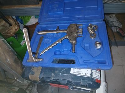 une mallette bleue contenant des outils, posée par terre