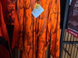 un imperméable orange accroché à un portemanteau dans un magasin de vêtements
