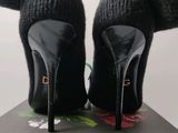 black high heeled shoes on a box with a pair of gloves on top