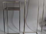 pair of metal and glass side tables on a white background